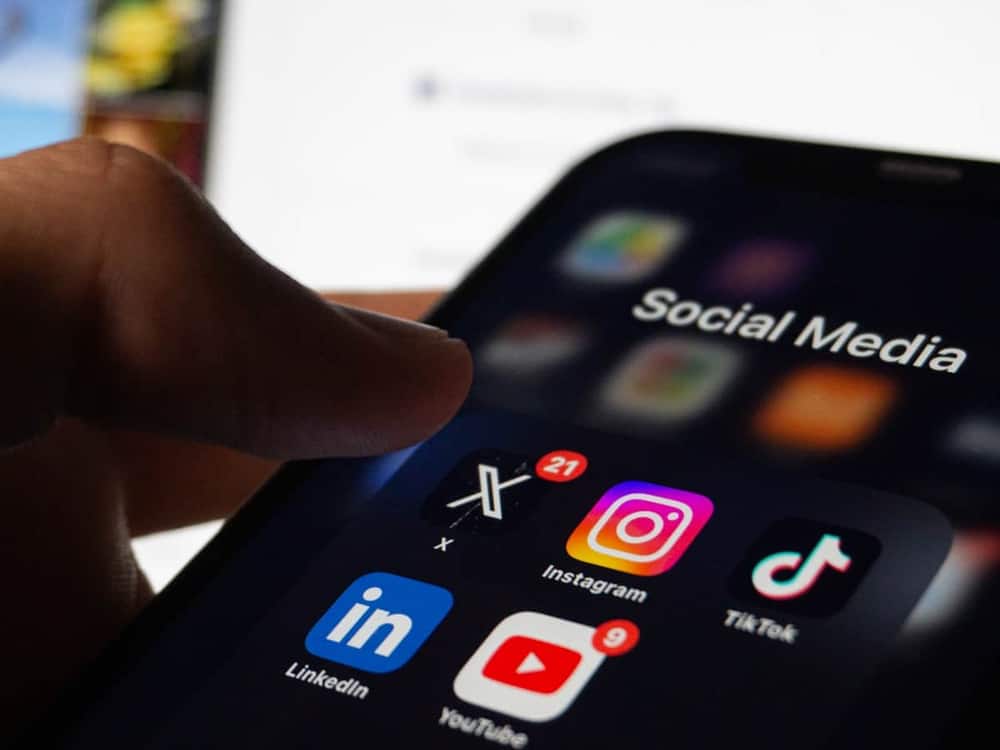 Persona abriendo las aplicaciones de redes sociales en la pantalla de un móvil